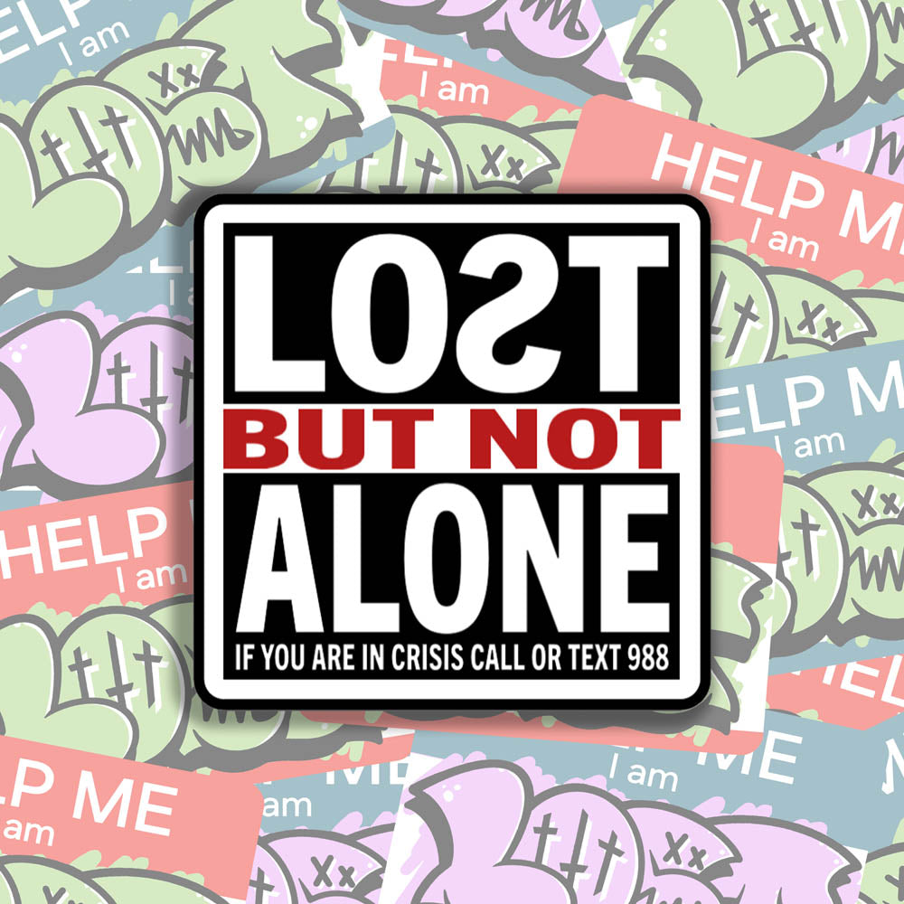 The Lost But Not Alone Sticker by artist and mental health advocate Christopher Reilly. This squared sticker features text stating Lost But Not Alone, if you are in crisis call or text 988. The black, white and red sticker design promotes mental health awareness and suicide prevention. A collection of colorful graffiti stickers makes up the background.