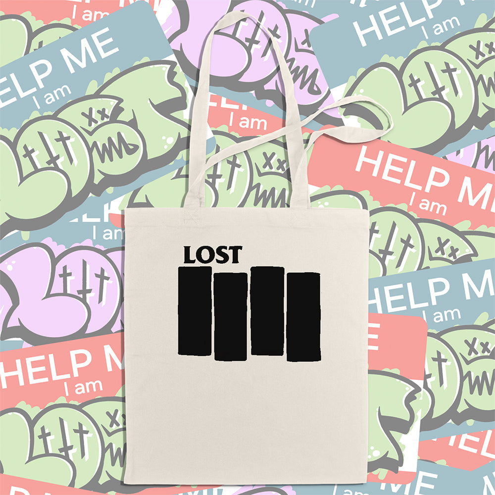 The Lost Flag tote bag. Four Solid black bars and the word LOST printed across a large, natural canvas tote bag. An assortment of colorful graffiti stickers makes up the display background.
