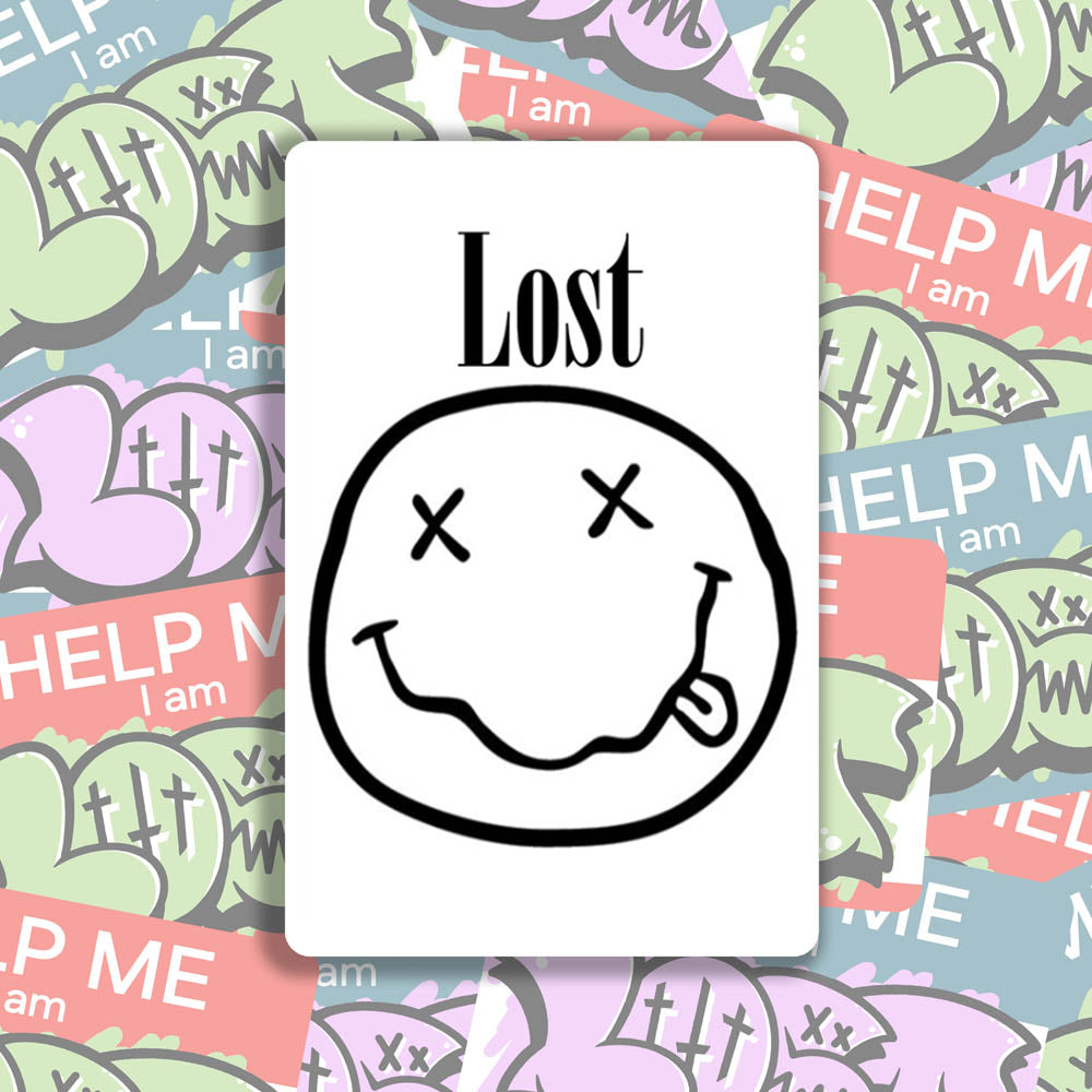 The In Bloom sticker by LOST. Black and white smiley face design with LOST written above it. A wall of colorful graffiti stickers provides a unique background for the sticker.